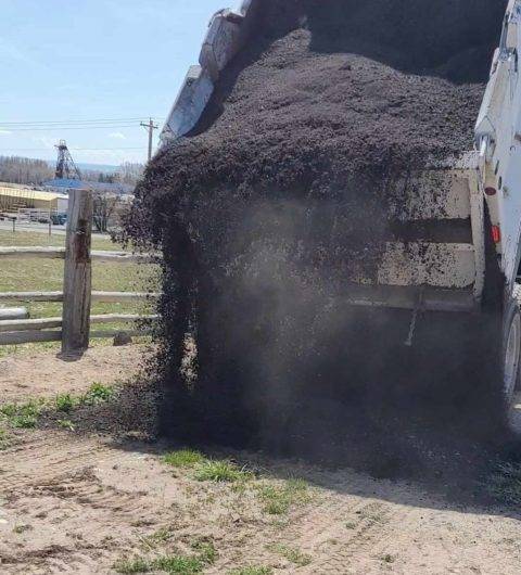 Crushed asphalt unloaded from dump truck.