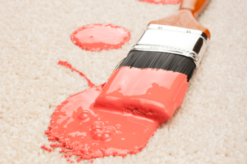 pink blob of paint on white carpet painting brush close up