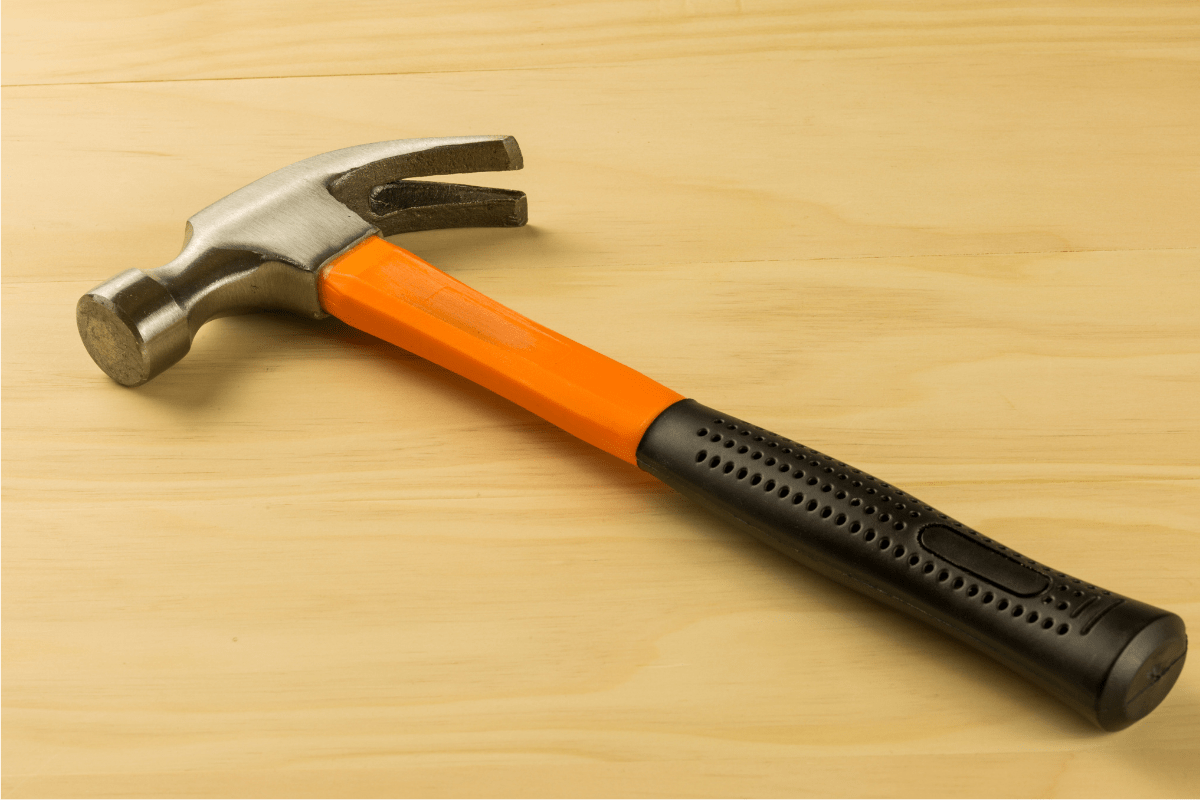 orange and black hammer on wood background