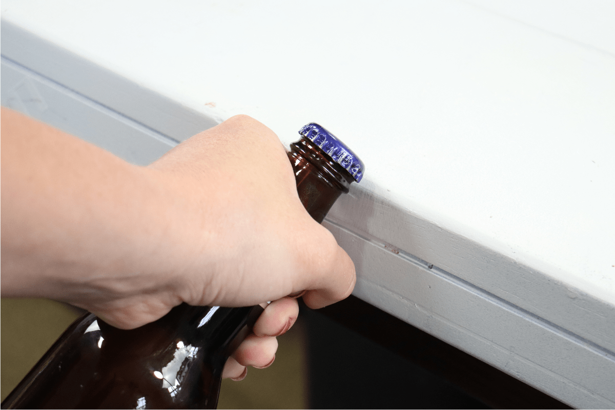 hand using white countertop to open beer bottle