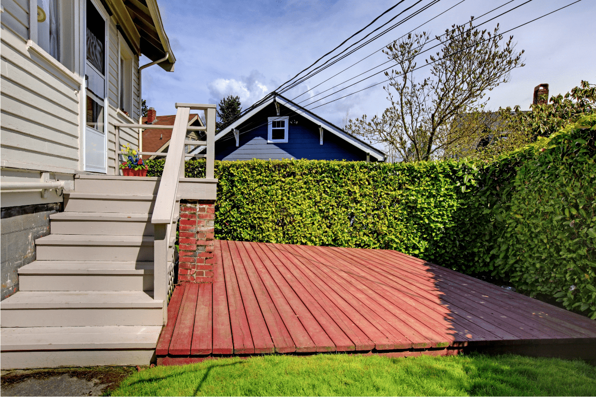 private deck evergreen hedge stairs on house