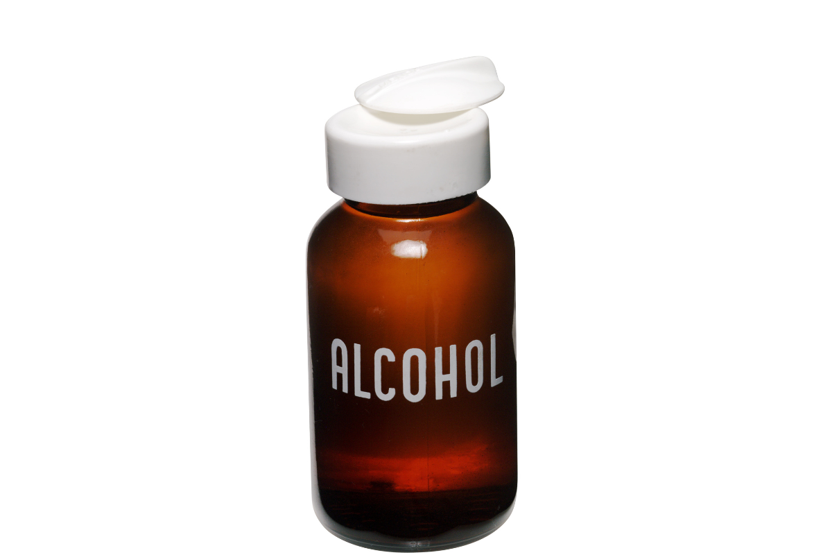 בקבוק ענבר שכותרתו אלכוהול עם מכסה לבן על רקע לבן