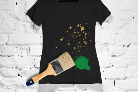black shirt on brick wall with green and brown paint splatter paintbrush
