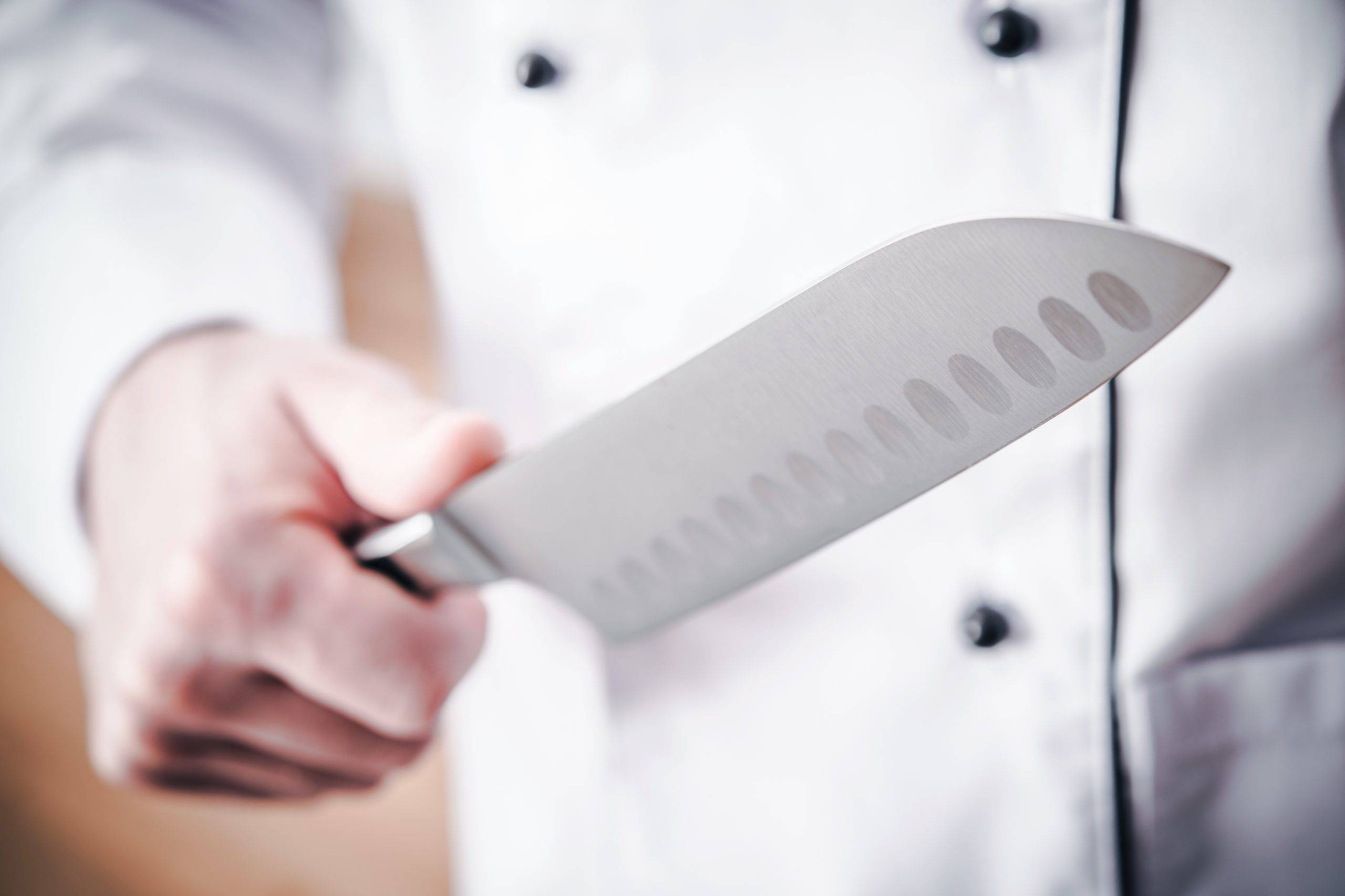 Kitchen Chef with Large Sharp Knife in a Hand. Meal Preparation.