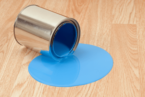 spilled blue paint tin can on light hardwood floor