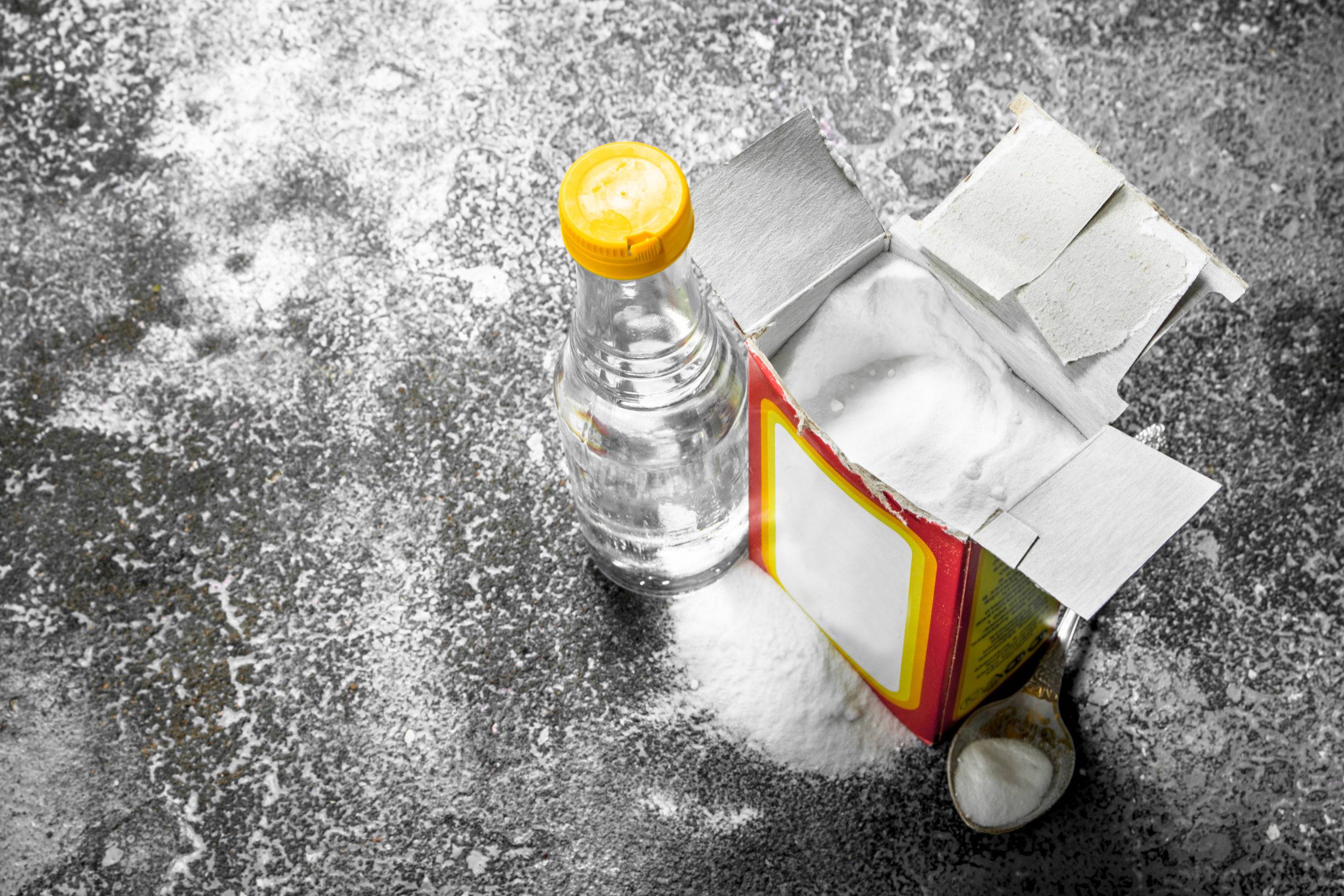 Baking soda with vinegar. On rustic background.