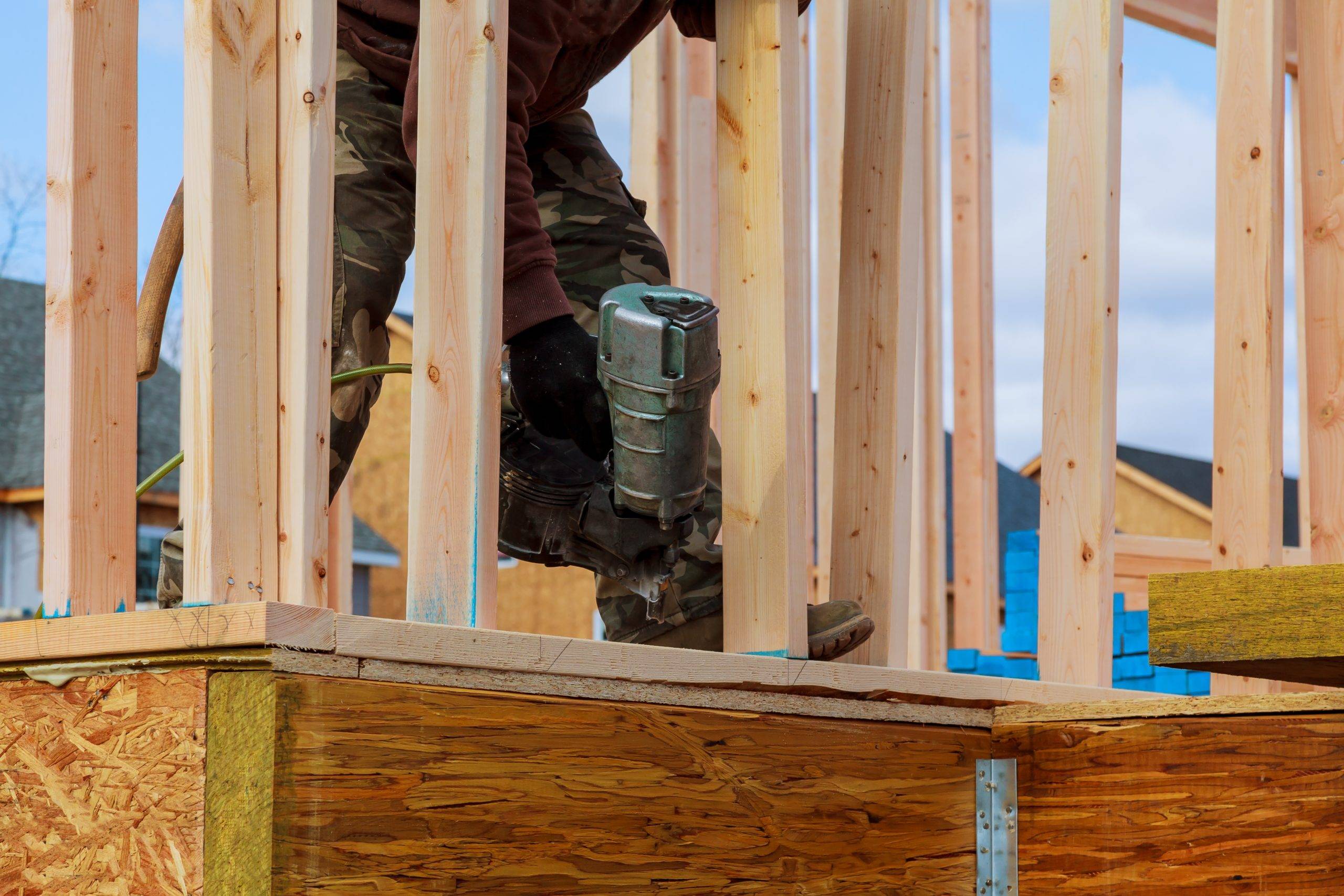 Building contractor worker putting in a interior wall partition nailer wall for the first floor on a new home construction project