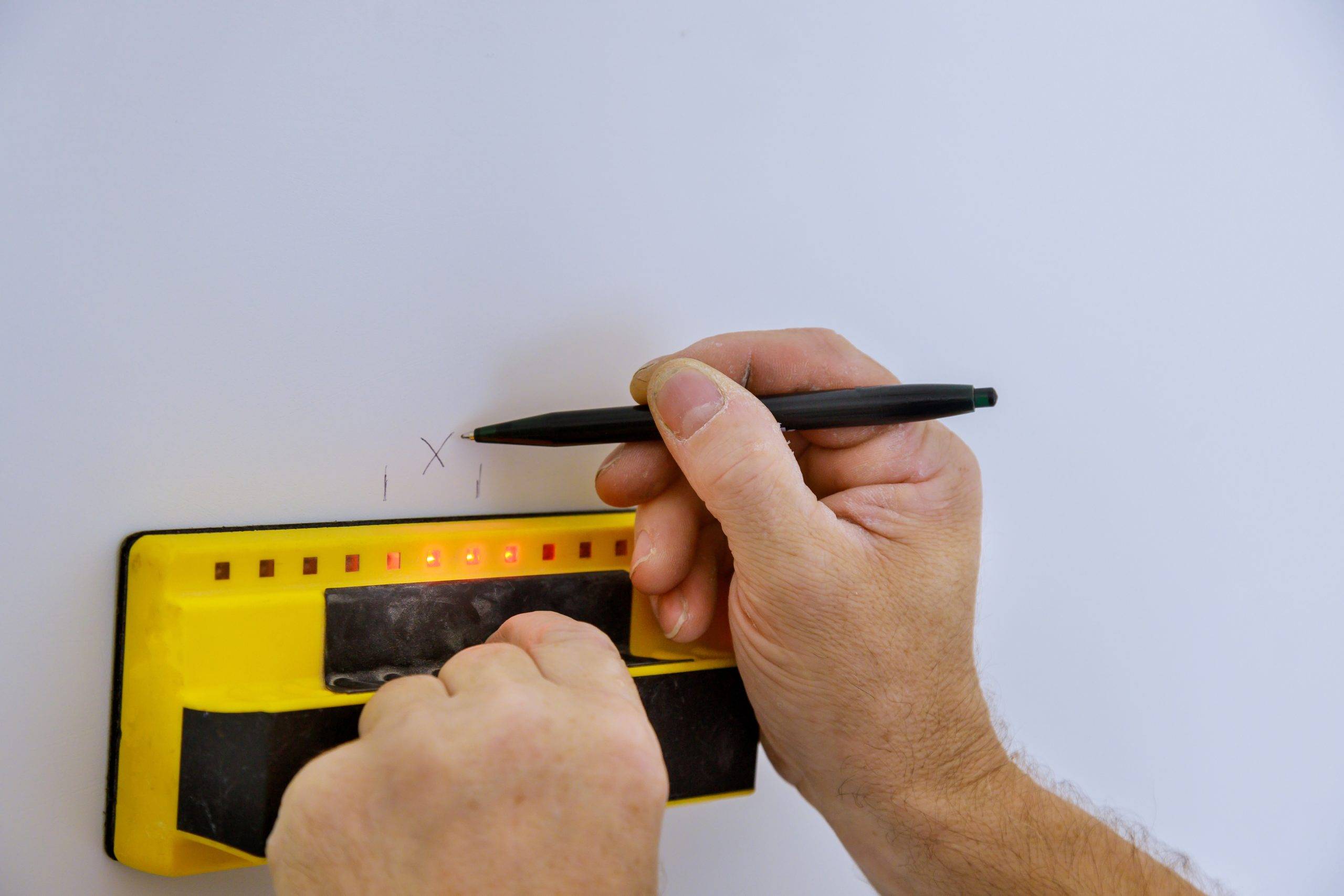 Digital detector man hand is scanning wall by sensors precision stud finder wooden beams soft focus