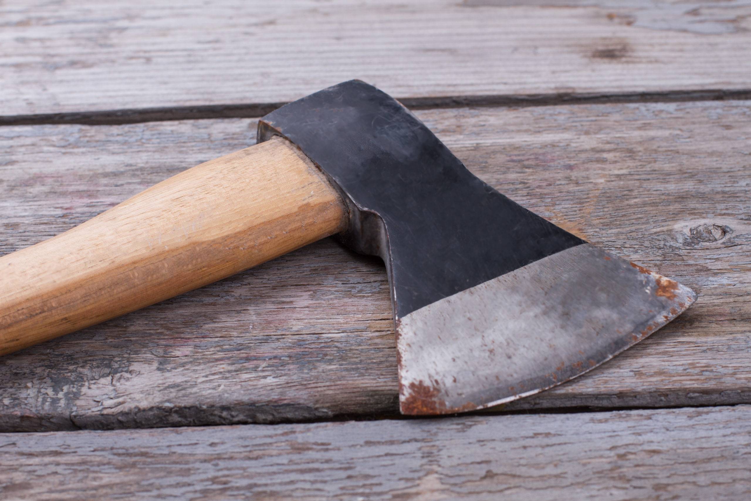 Old axe on vintage wooden background. Tool on wooden boards.