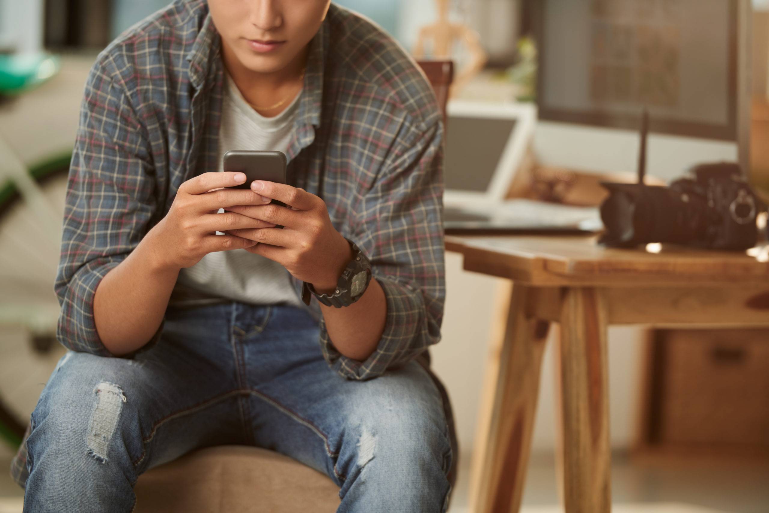 Cropped image of young man using application on his smartphone