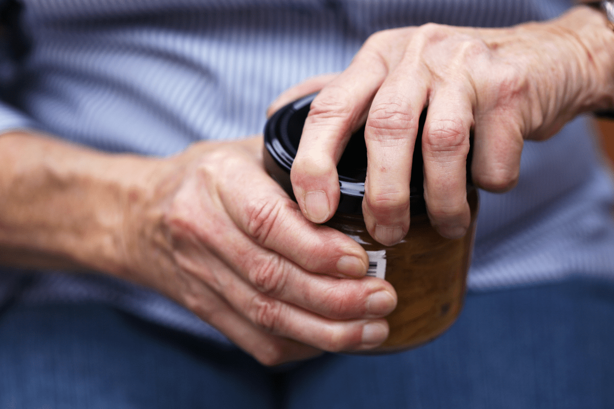 elderly hands opening stuck jar close up