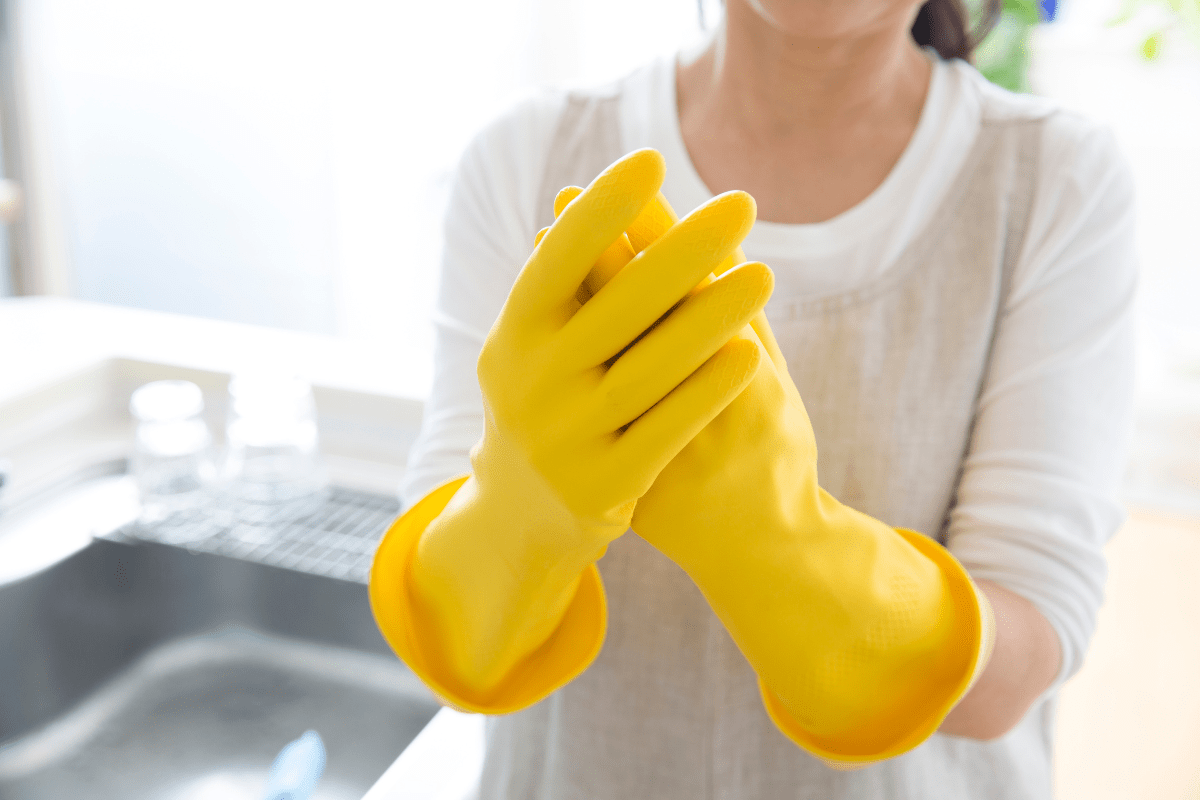 close up of woman wearing yellow rubber gloves