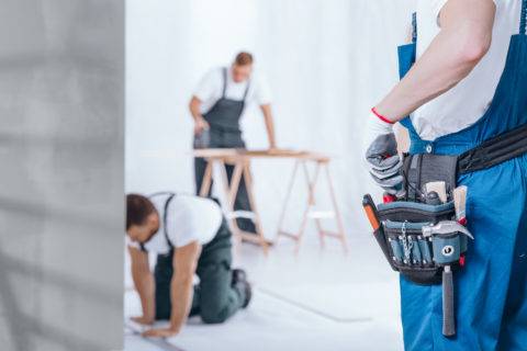 three handymen in overalls working on project