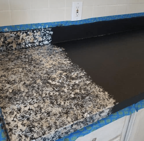 Half painted countertop that's masked with tape.