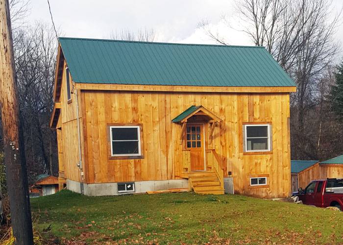 Tiny home on a concrete slap foundation with a green roof.