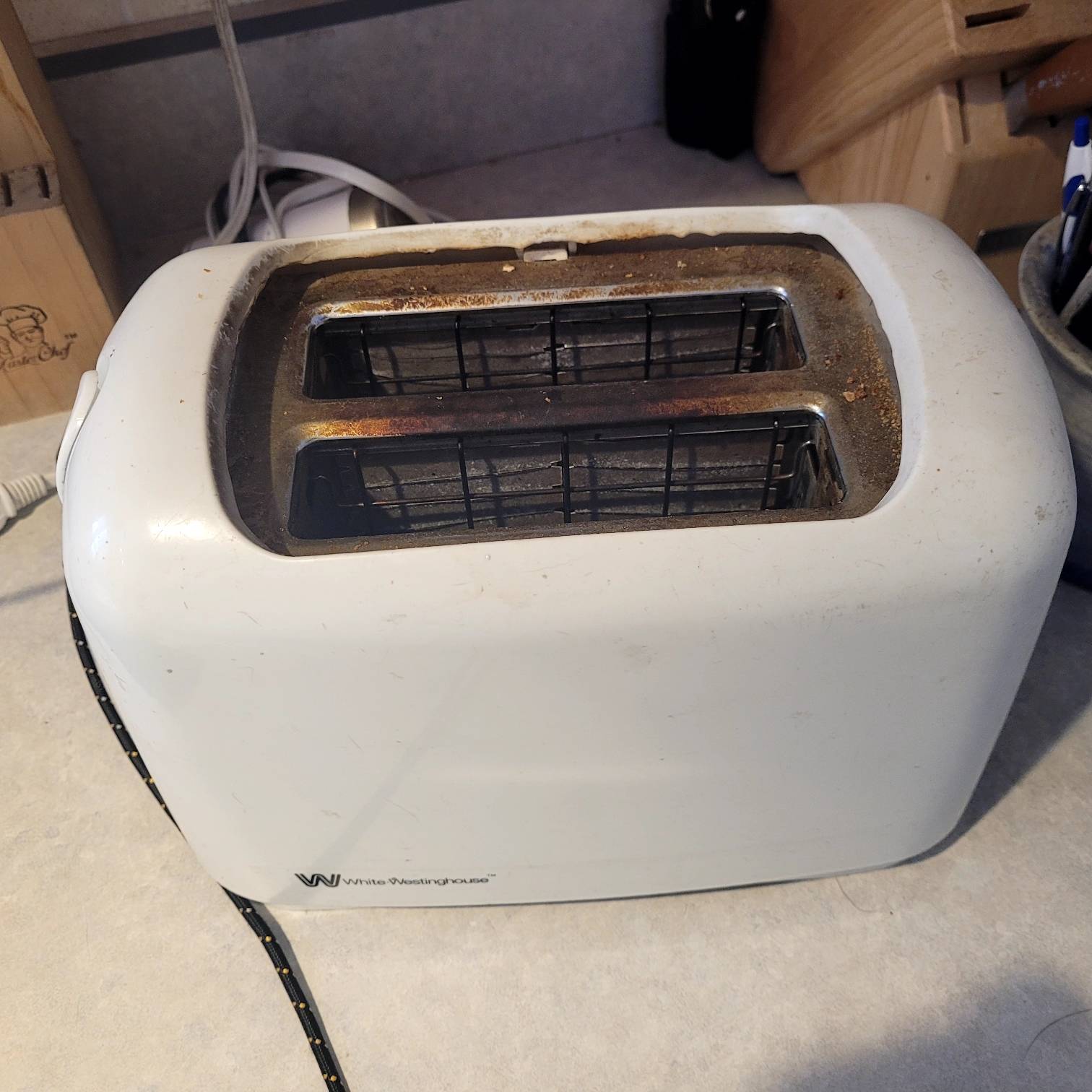 white two slot toaster with rusted metal slots