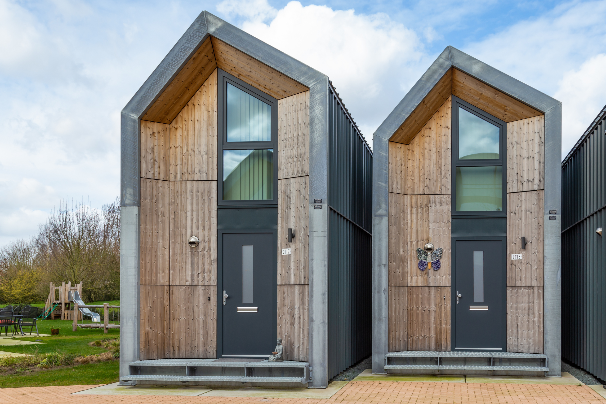 Two tiny homes with modern styling and black front doors.