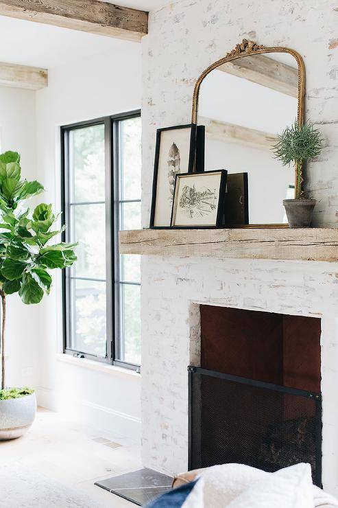 white brick fireplace with live wood mantel and decorative accents