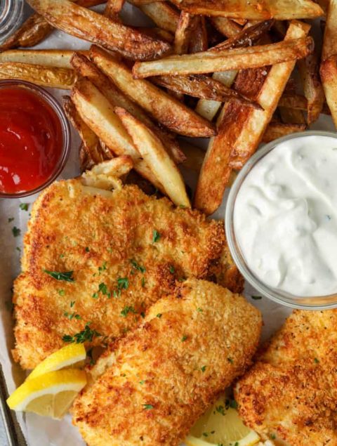 crispy fried fish pieces with tartar sauce and fries on plate