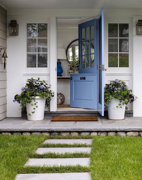 white front porch with large planters and open blue periwinkle door