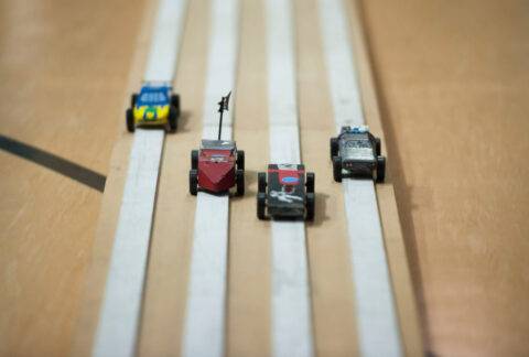 Cars speed down pinewood derby track