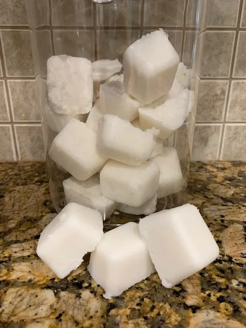 home made dishwasher detergent tabs in glass jar on ktichen counter