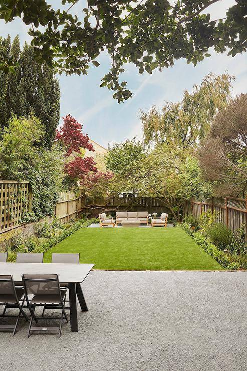 view from back porch of green garden backyard with wooden furniture at back