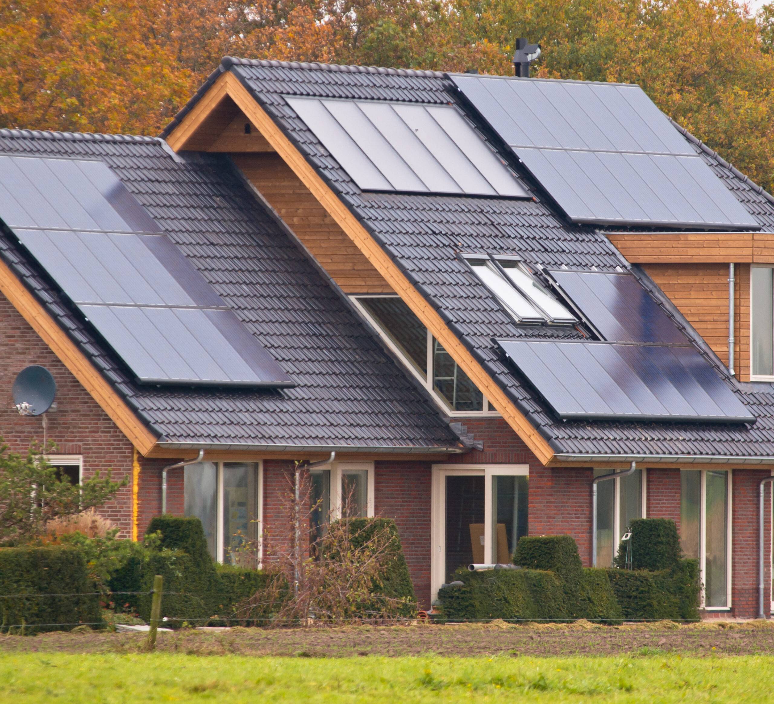 cabin style home with solar panels on black roofing