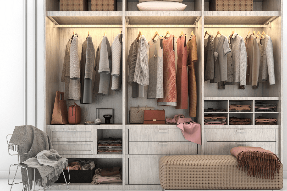 shot of closet gray wood closet organzier with hanging clothes bench in front chair with blanket throw