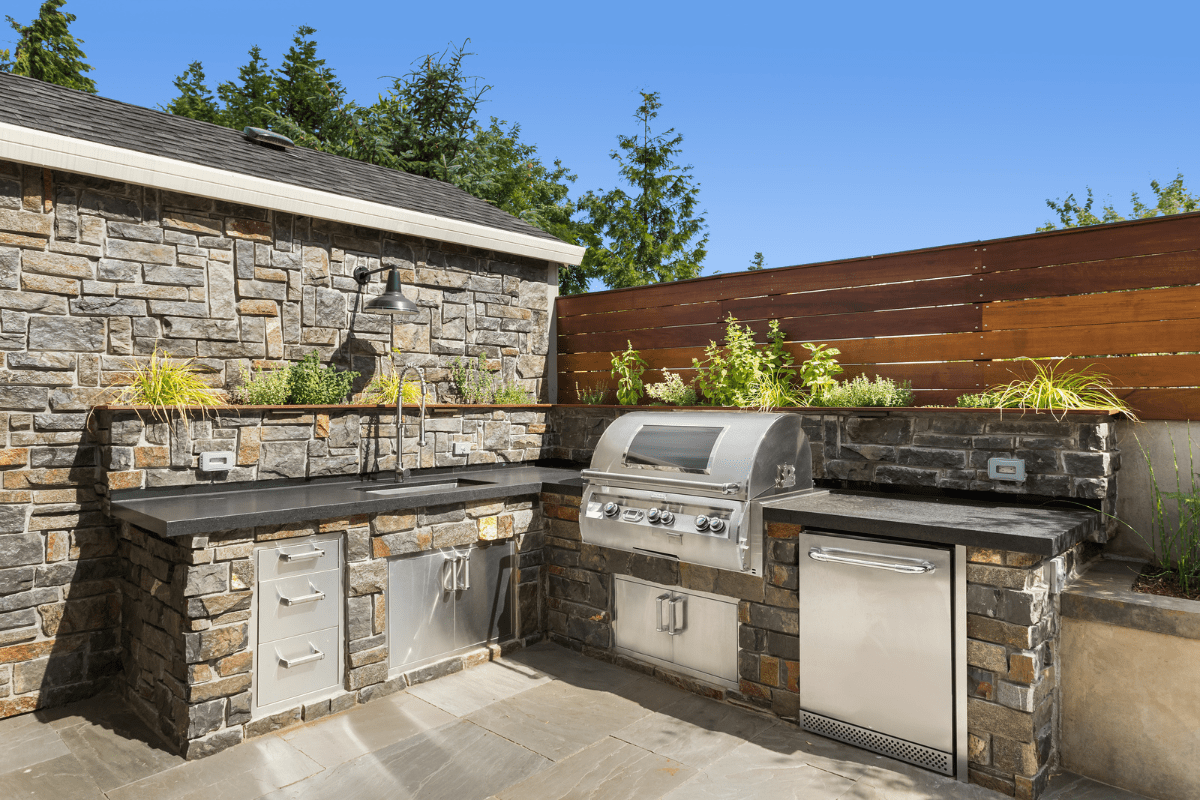 outdoor kitchen with stone wall bbq dishwasher