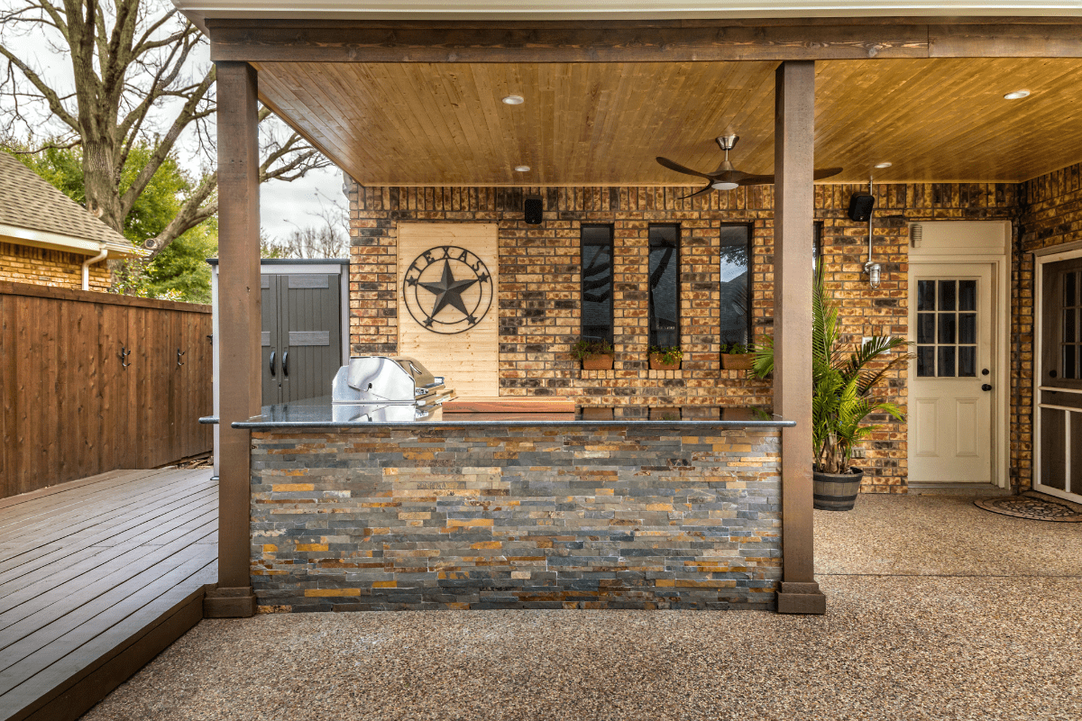 outdoor kitchen with stone island large pillars and clean deck