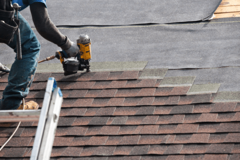 man on roof with a nail gun