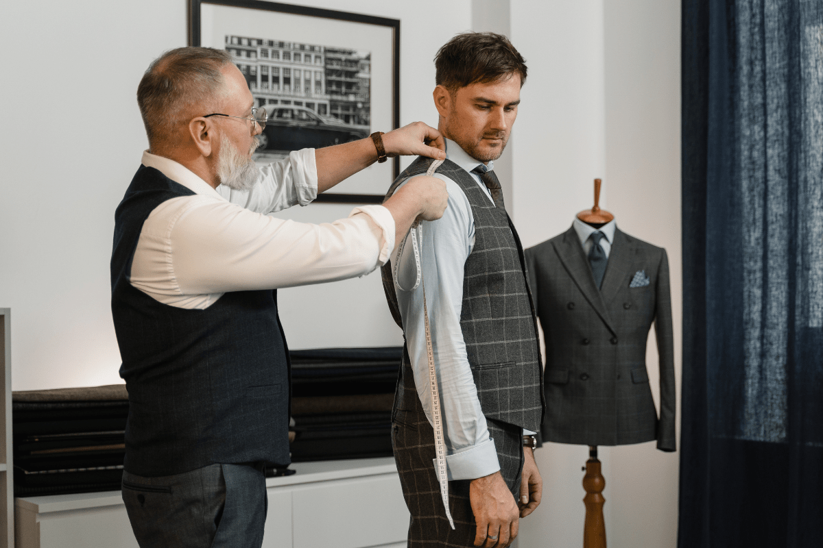 man being measured by a tailor