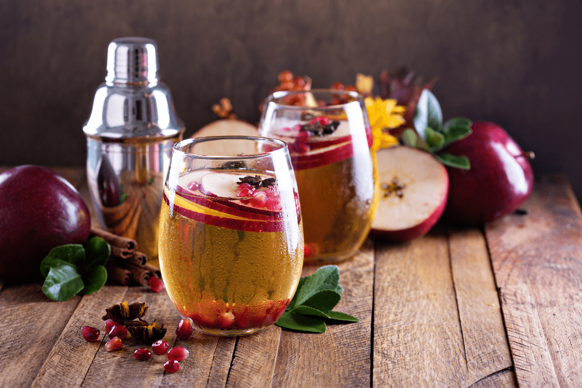 spiced apple cider cocktail drink on wood background