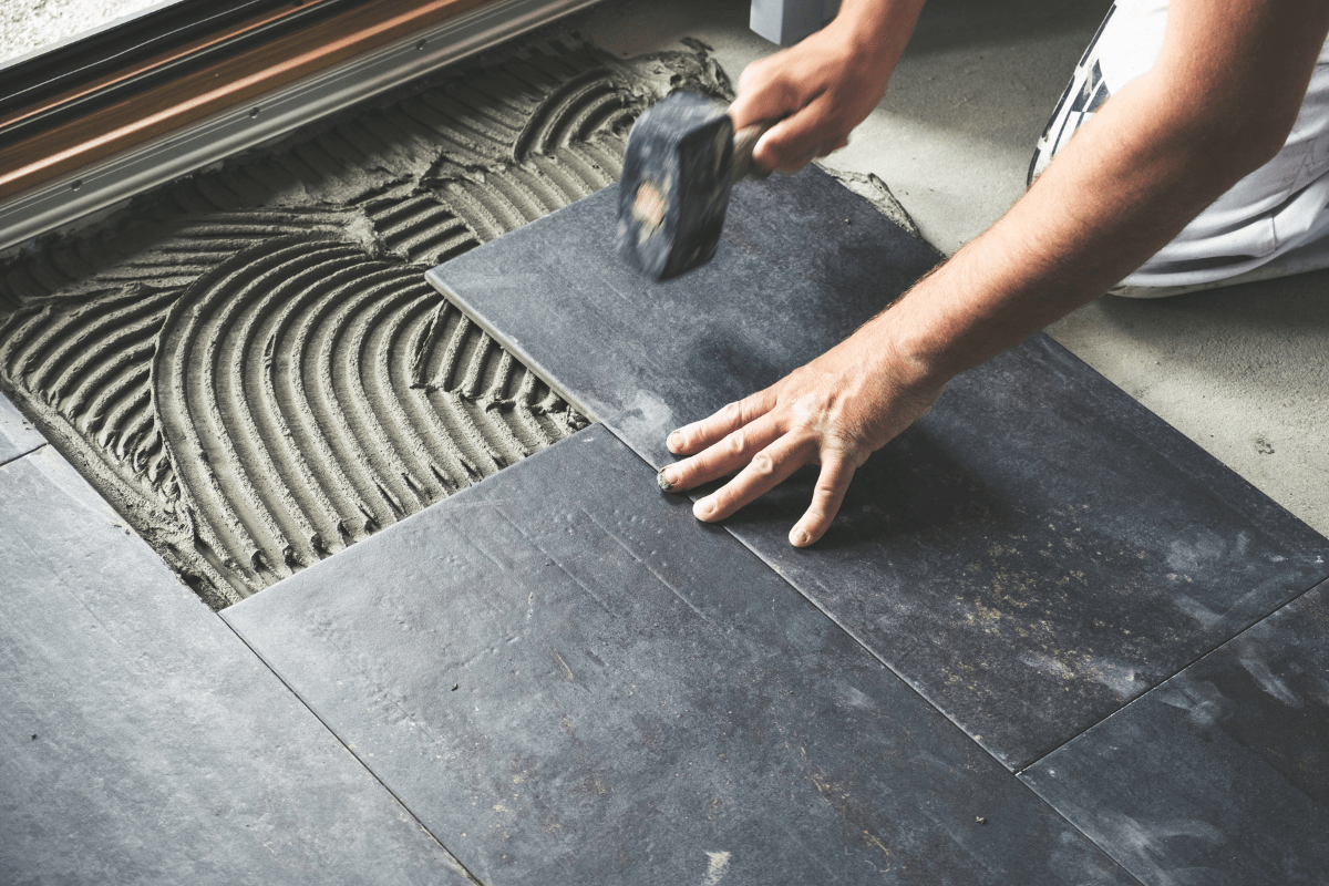 man laying ceramic tile