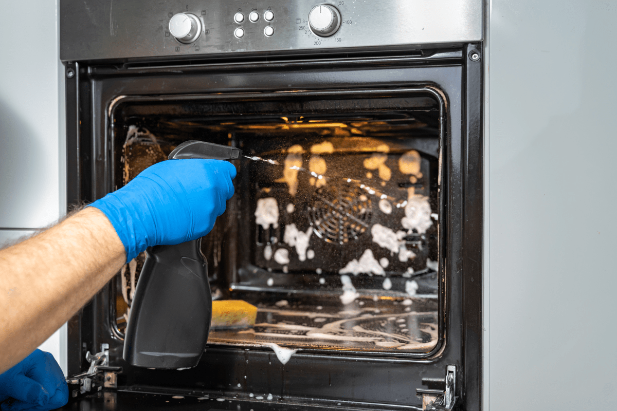 spraying cleaner in an oven