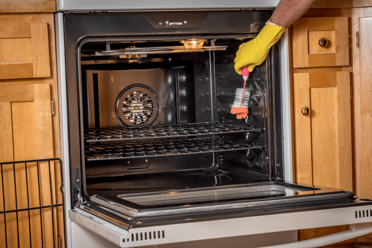 cleaning an oven with scrub brush