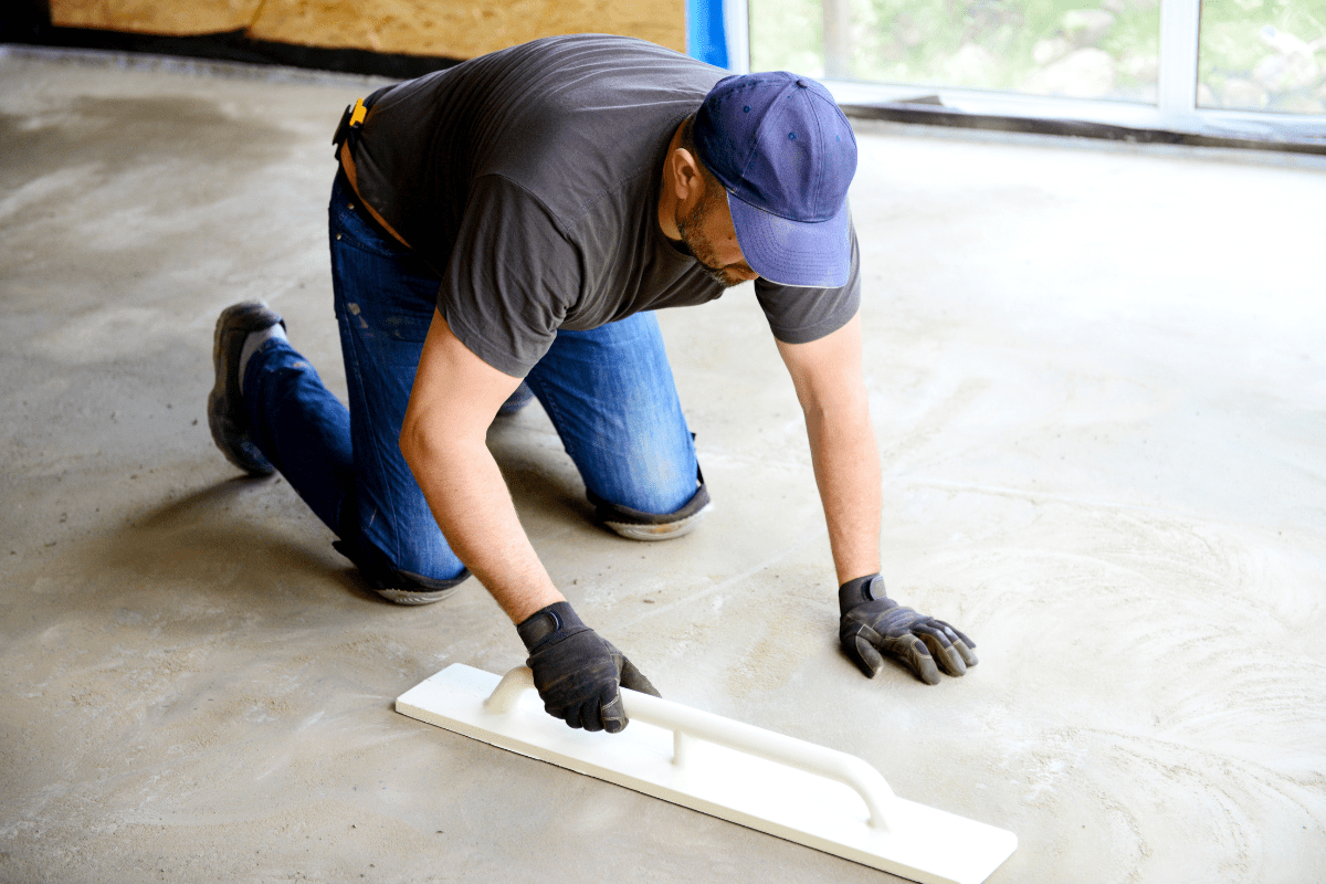 man laying down a concrete floor