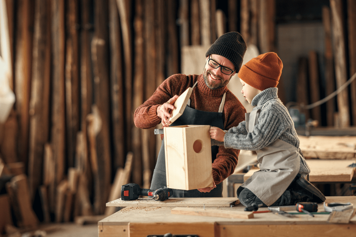 Dad and kid assembling wooden bird house