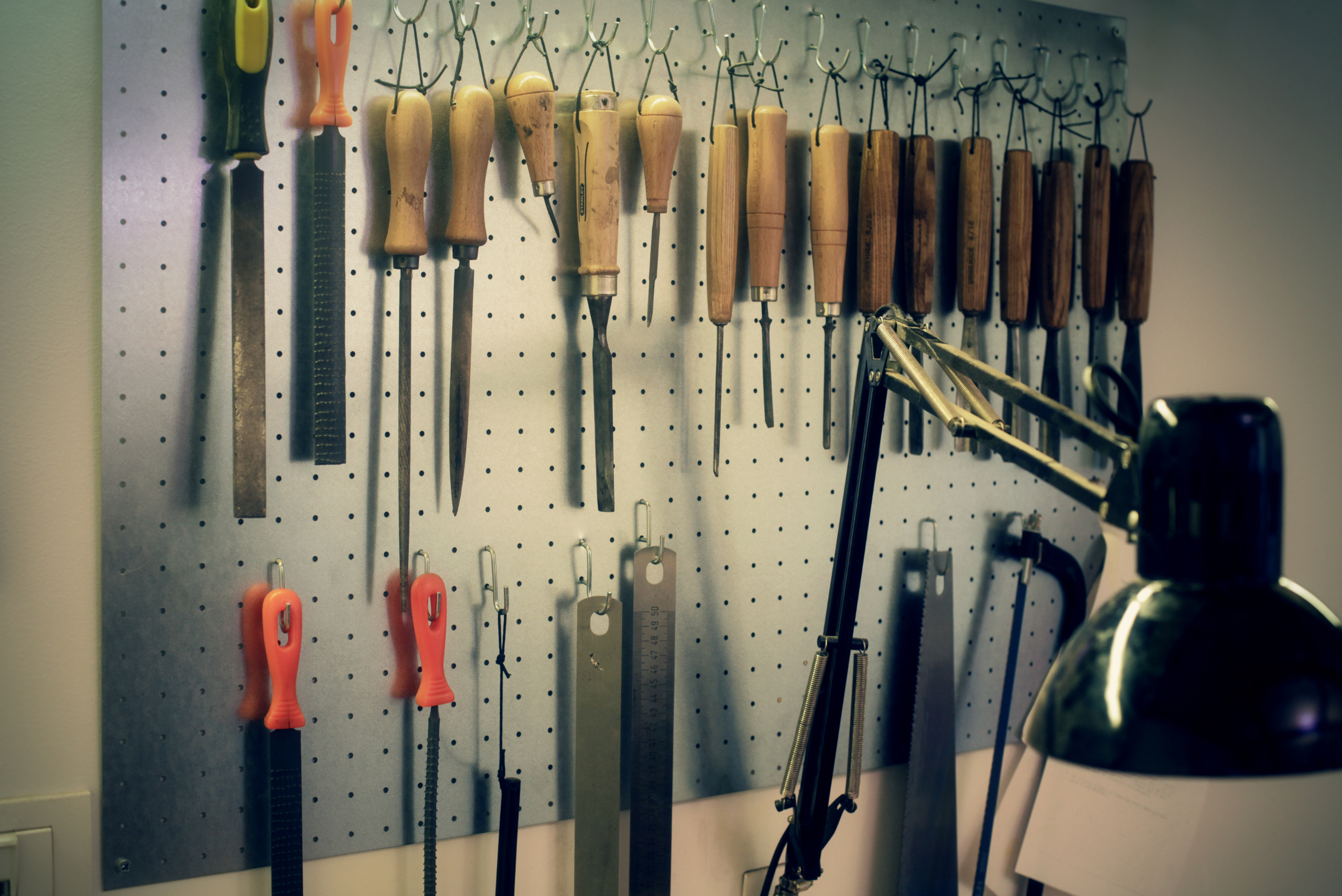 A tool bench flanked by wood-working tools hung on the wall.