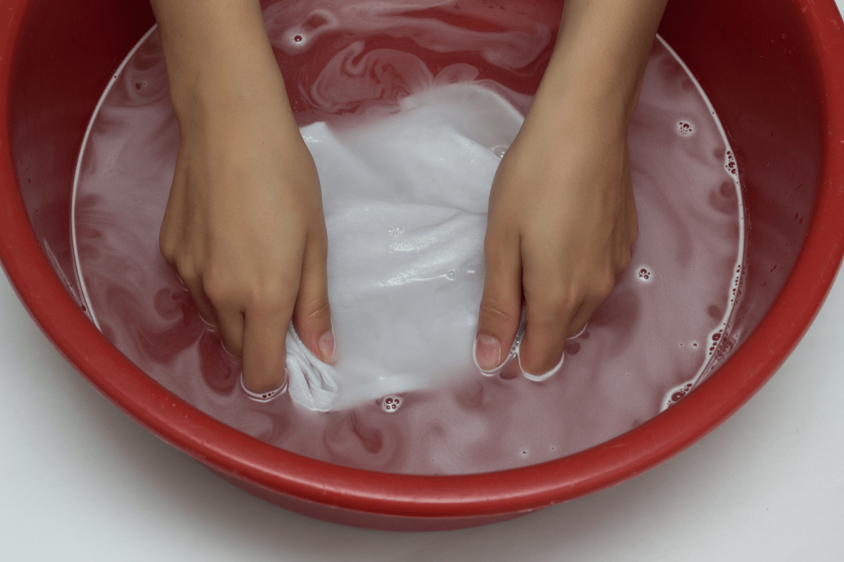 washing white shirt in red bowl.
