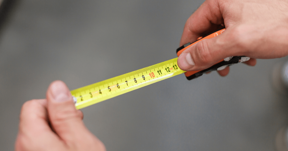 Construction tape. Measurement. A man measures with a tape measure.