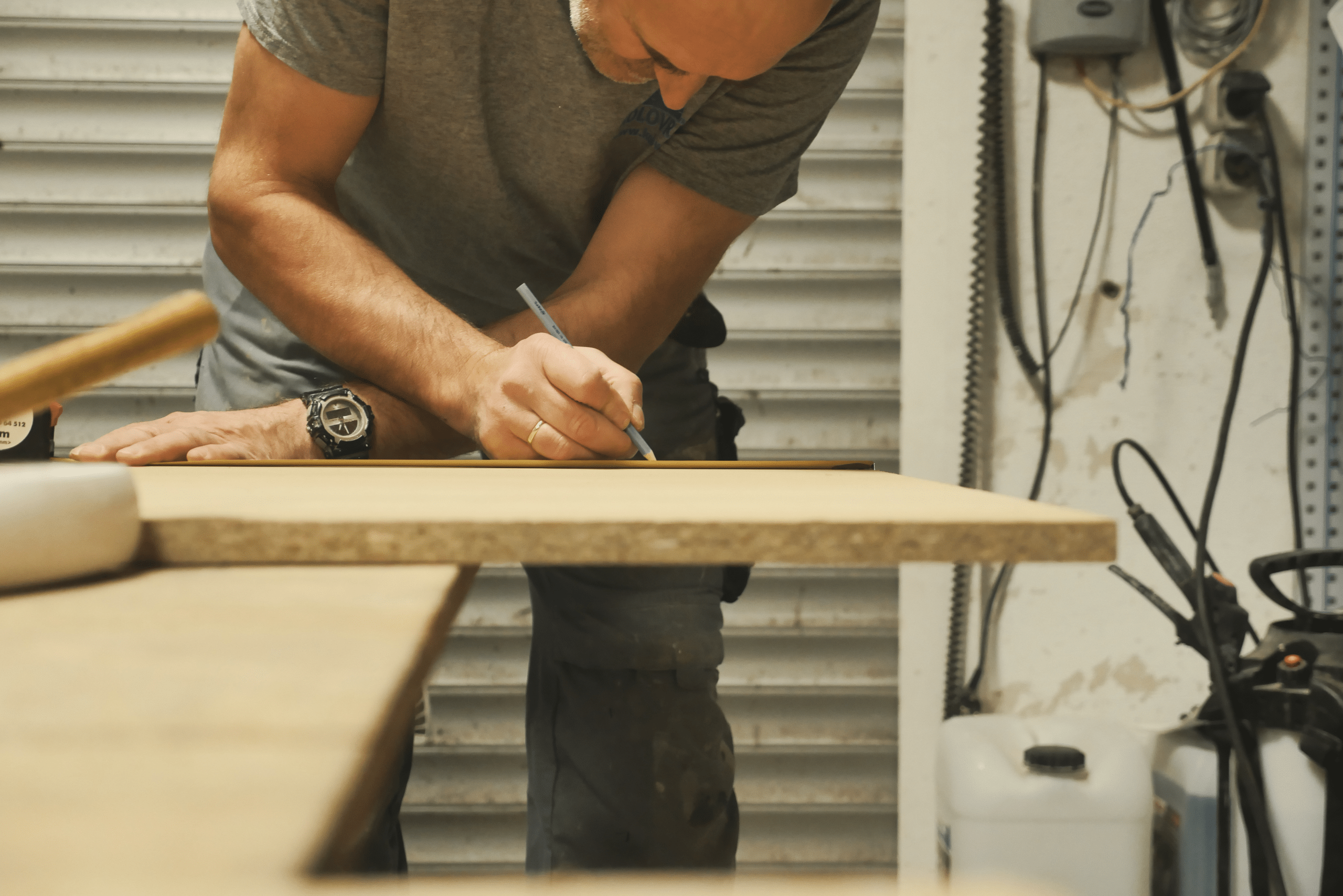 Person drawing a straight line across MDF board