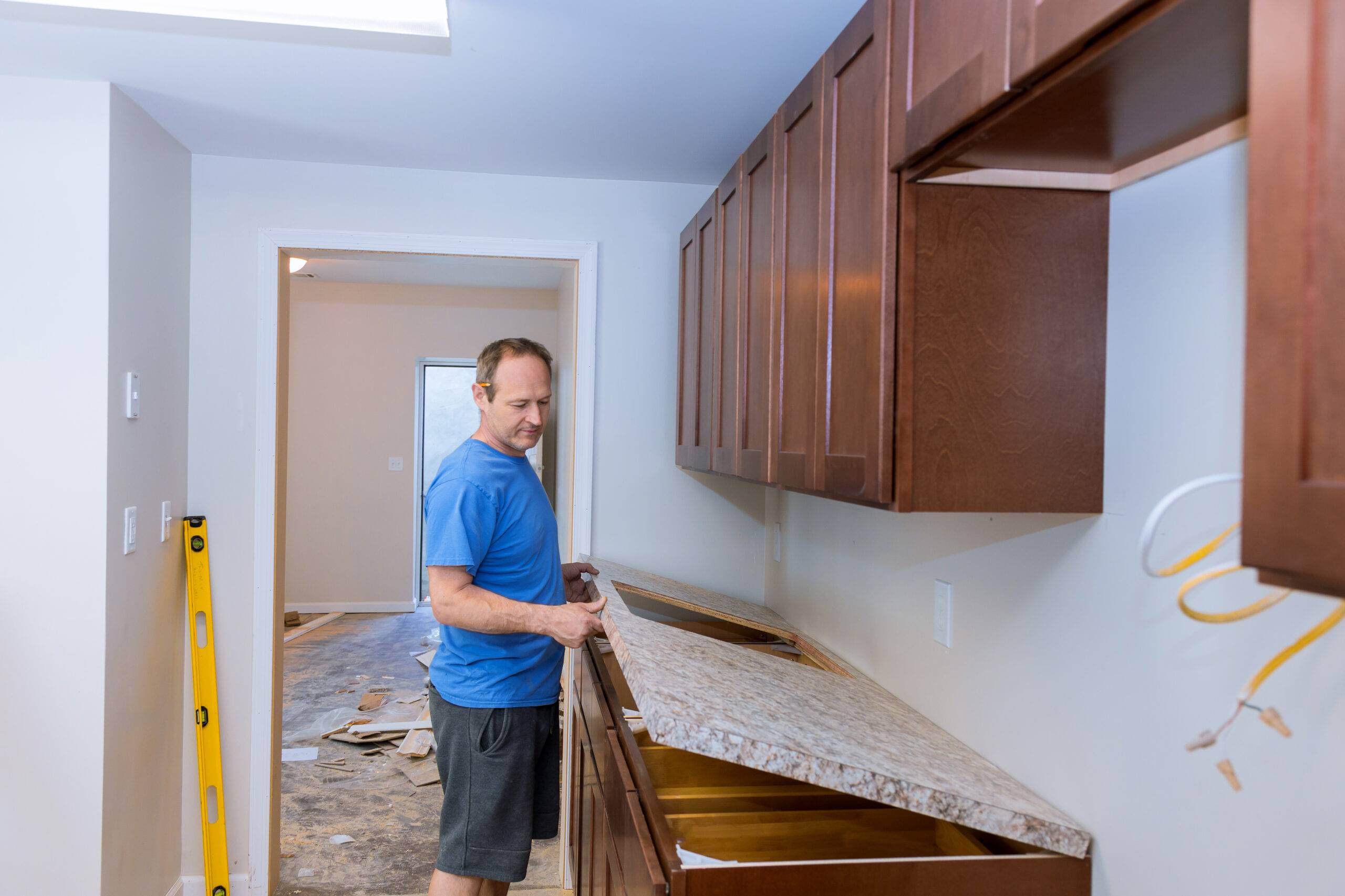 Carpenter installing c counter top in a kitchen remodel.