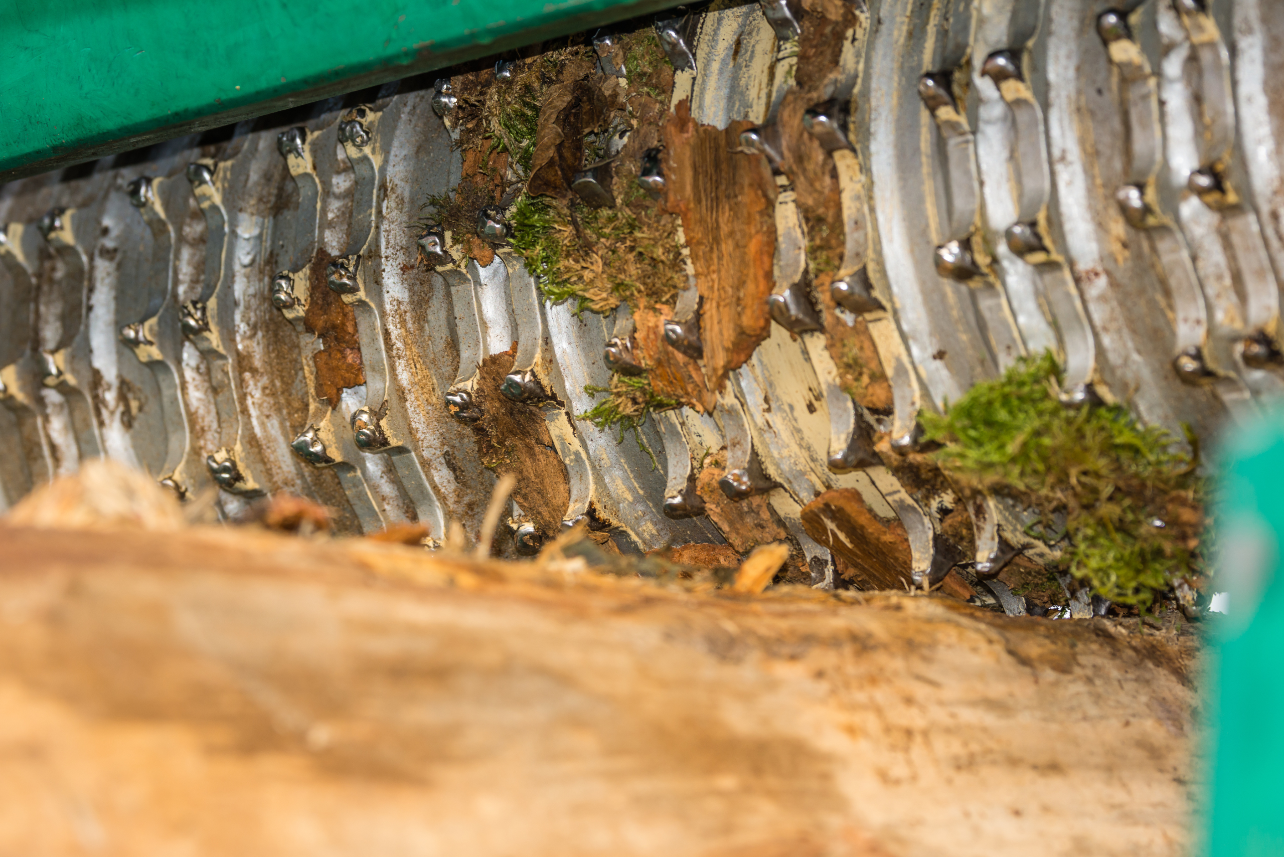 Heavy-duty wood chipper debarking a piece of wood