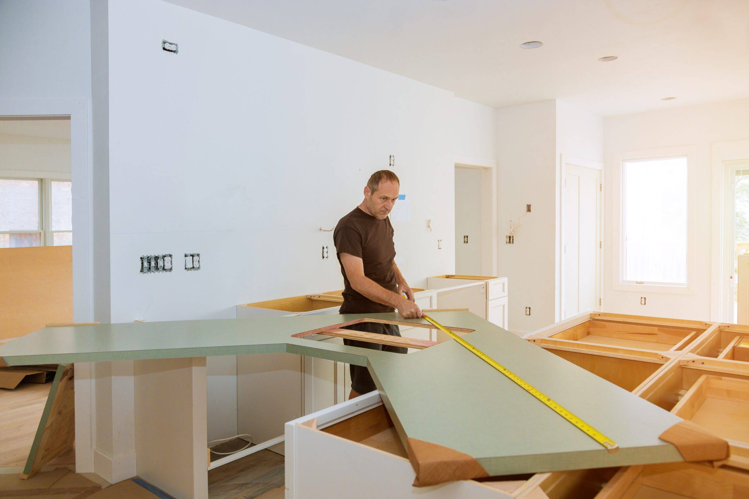 Installing laminate kitchen counter top during a kitchen remodel.