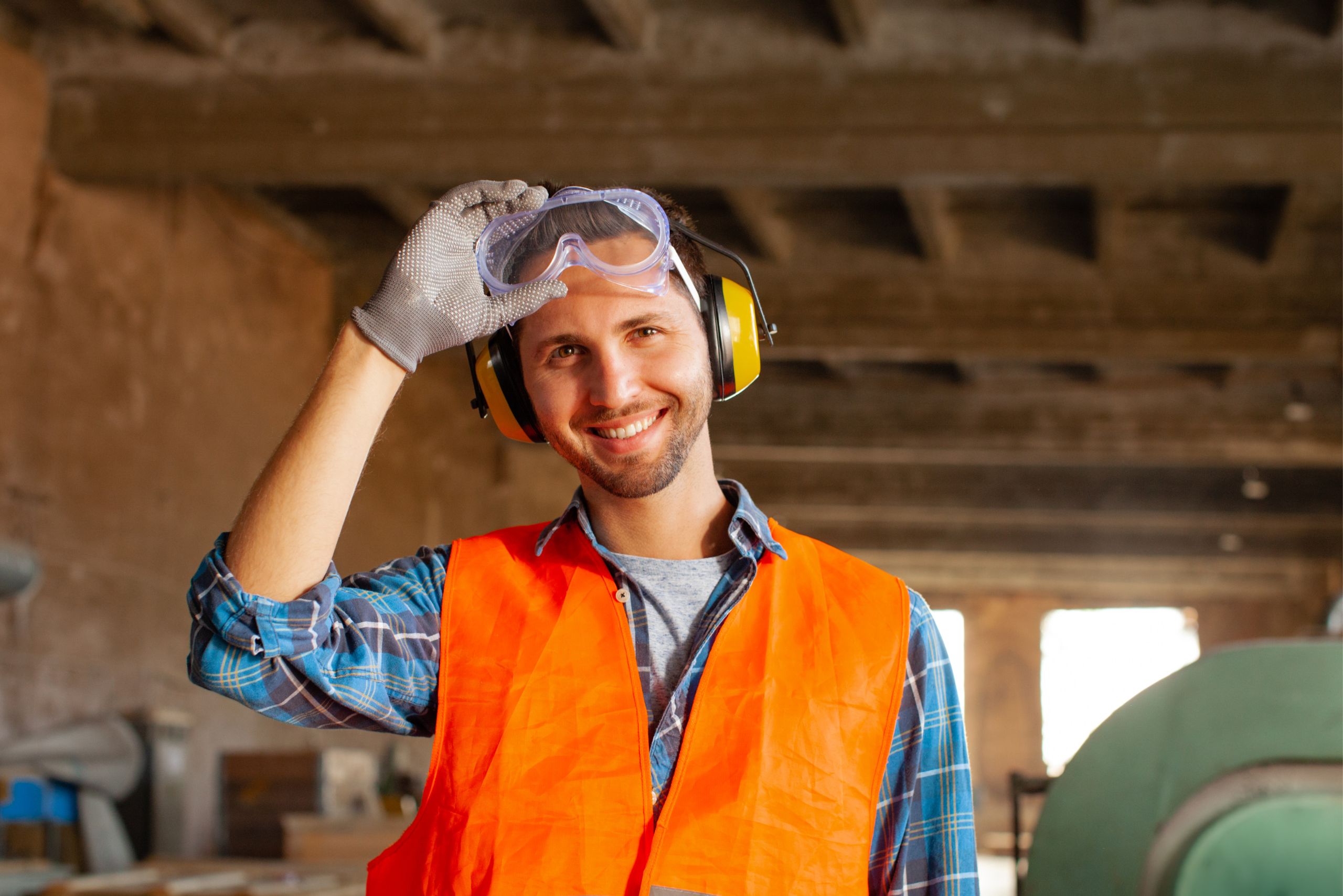 A person wearing safety vest, hearing protection, and safety glasses.