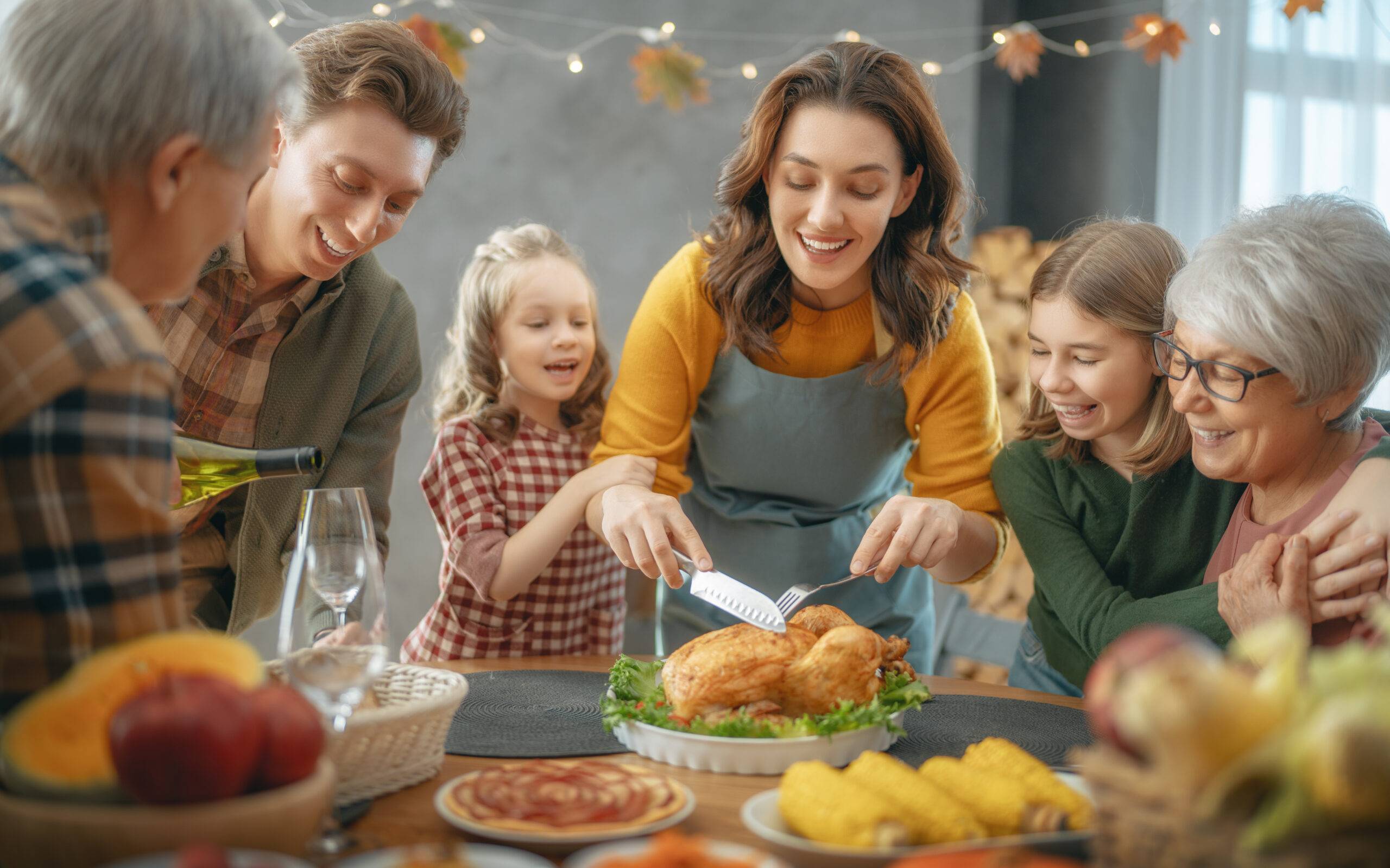 Thanksgiving Day, Autumn feast. Happy family sitting at the table and celebrating holiday. Grandparents, mother, father and children.