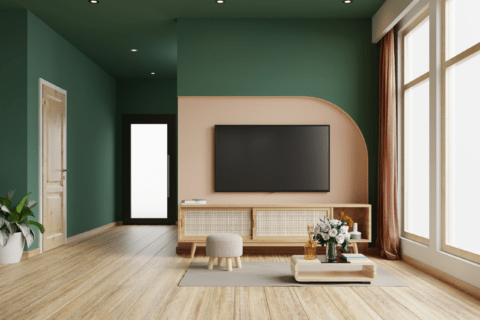 Room with green walls featuring a natural wooden TV stand.