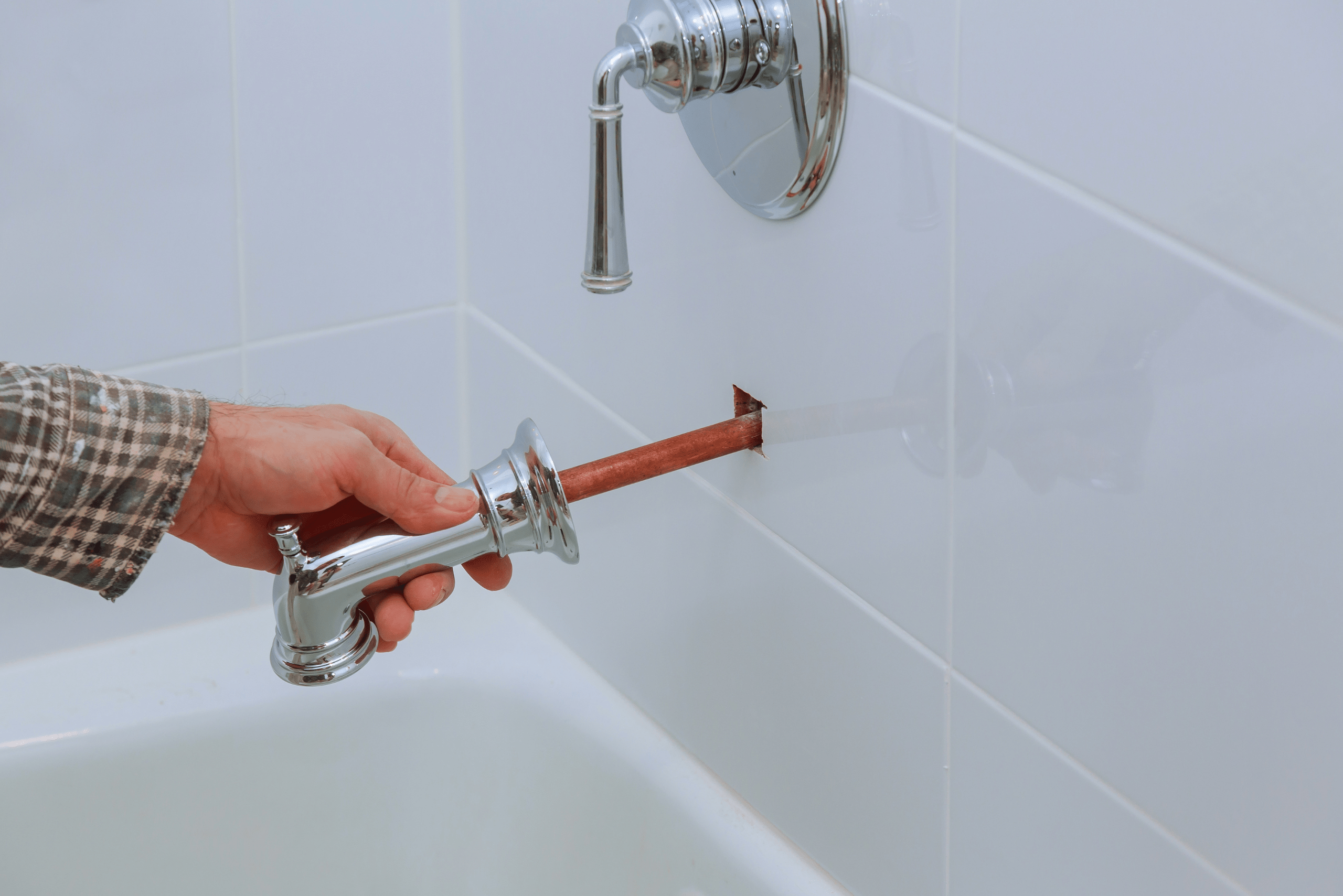 Person removing bathrub faucet.